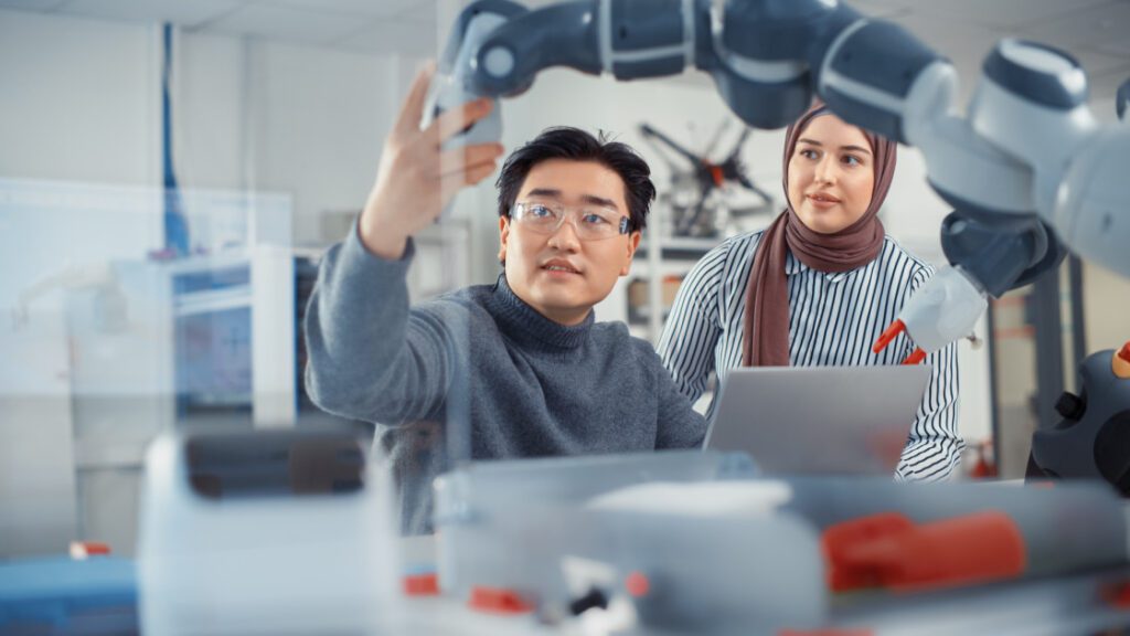 Seven Research Topics on the emerging technologies disrupting the world of science Horizontal Arabic Female Future Engineer Looks At Work Of Skilful Developer. Asian Man Explains Core.jpeg
