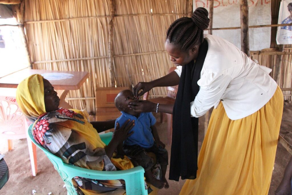 A Nurse Provides Vaccine To 18 Month Old Osman As He And His Mother Zeinab Cross From Sudan To South.jpeg