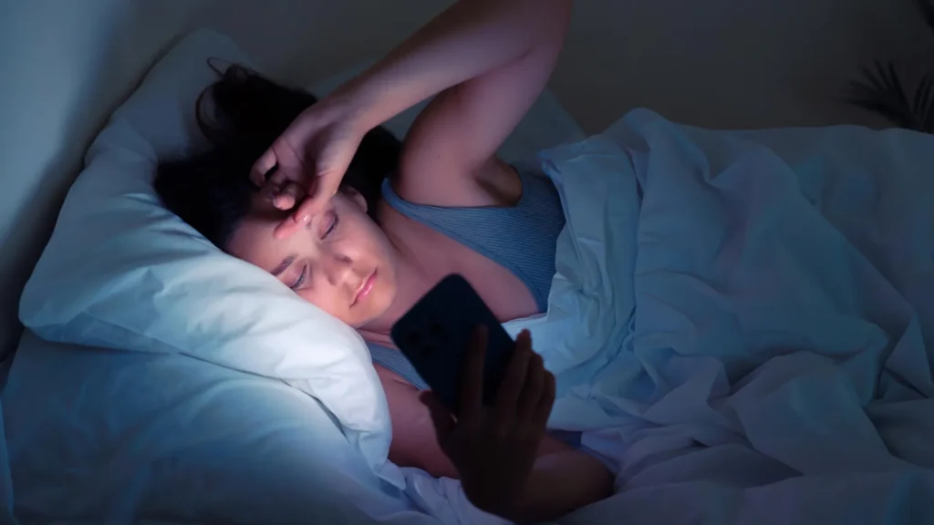 Experts warn: Smartphones before 13 could harm mental health for life Girl stress bed cell phone.webp.webp